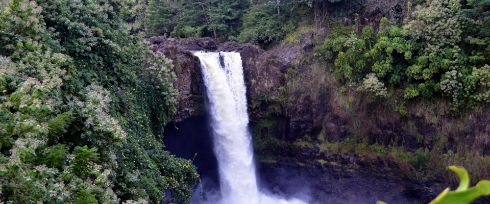 Waterfall surrounded by lush greenery, labeled 'Rainbow Falls, Hilo HI'.